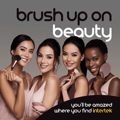 Four women smiling while applying makeup